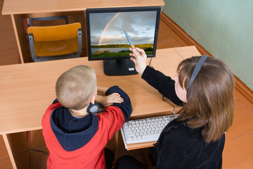 Schoolboys in a computer class work behind computers