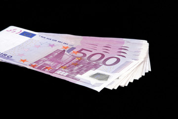 500 Euro bills currency on a black background