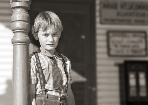 Black And White Of A Young Boy In Tie And Braces 