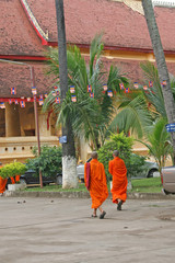 Two Buddhist monks walking in the grounds of a temple in Bangkok