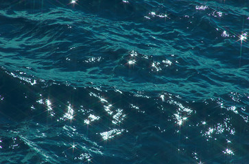 Obraz premium Patches of light of the sun on sea waves