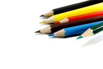 six coloured pencils over white background
