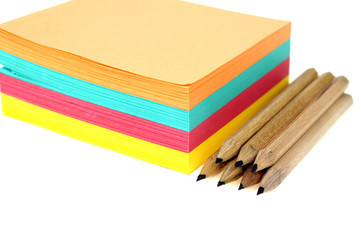 Fototapeta premium Stack of colorful post-it and pencils isolated on white