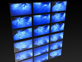 big panel of TV’s on black background