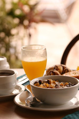 Früstück mit Saft, Müsli, Croissant und eine Tasse Kaffee