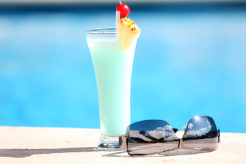Cocktail und Sonnenbrille am Schwimmbad