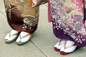 Obraz premium Détail des pieds de deux femmes japonaises en vêtements et costume traditionels japonais avec kimono, chaussettes (tabi) et sandales (zori)
