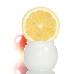 Cosmetics cream with lemon and apple on the white background
