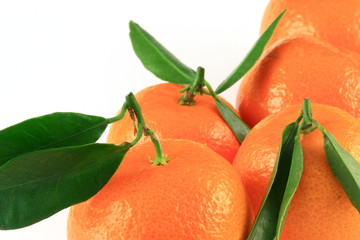 fresh mandarins close-up on a white background with green leafs