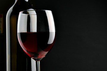 Bottle and glass over black background with space for text