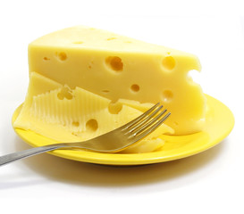 Piece of cheese on the plate with fork isolated over white