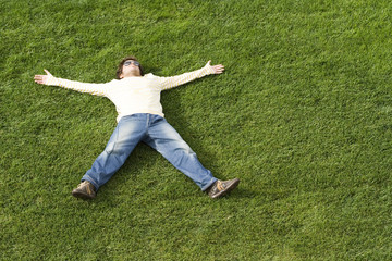 Fototapeta na wymiar young man enjoying nature sleeping on the grass