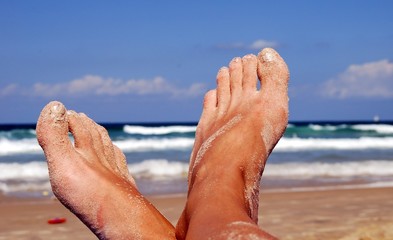 female feet on back-ground sea in sand.