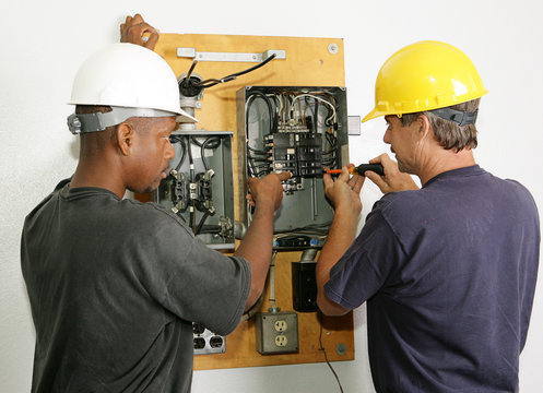 Electricians repairing breaker panel.  Actual electricians