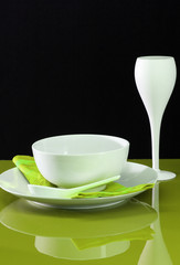 A contemporary dinning table set with plate, bowl and wine glass