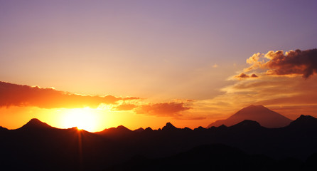 Fototapeta na wymiar raising sun beams illuminating an Elbrus mountainside.