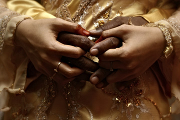 hands of man and women of different color, interracial marriage
