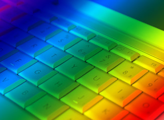 close-up of laptop keyboard overlain with rainbow colors - Powered by Adobe