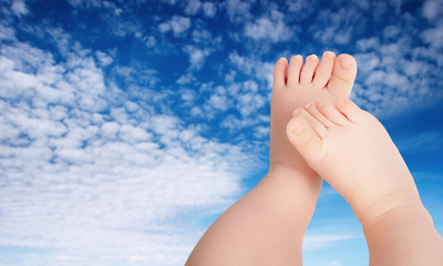 Baby legs against blue sky background