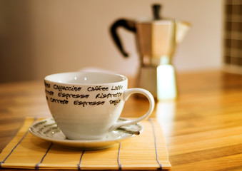 Coffee cup with espresso maker in background