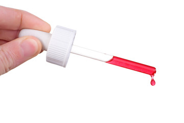 male hand holding dropper with red liquid  dripping 