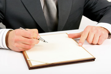 businessman is starting to write something on the white paper