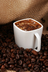 Coffee cup surrounded by coffee grains