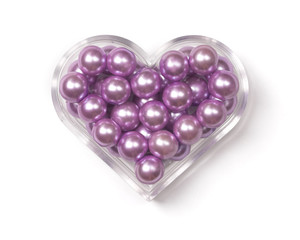 Heart-shaped plastic box with pink pearls in it.