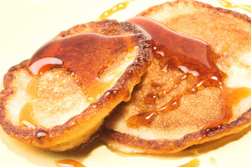 Close-up of two pancakes with maple syrup.