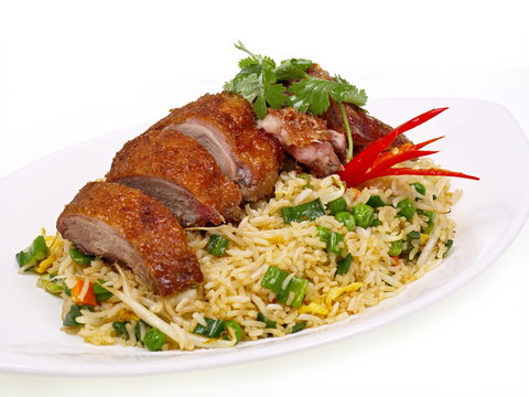 knusprige Ente mit gebratenem Reis auf einem Teller freigestellt auf weißem Hintergrund