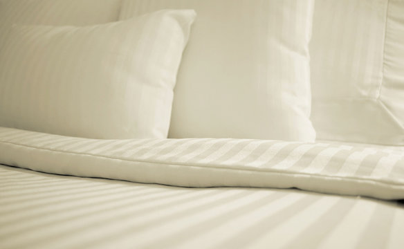 Bed With Set Of Crisp Striped Sheets And Pillows