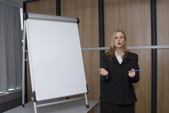 Einladende Geste einer Trainerin beim Seminar