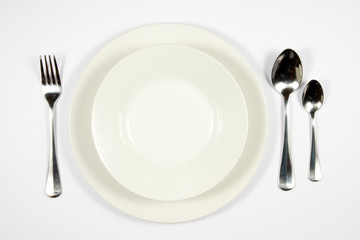 A place setting for dessert against a white background