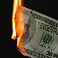 Burning dollars close up over black background - obrazy, fototapety, plakaty