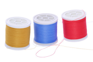 three plastic spools of colored yarn