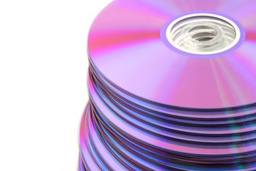 Stacked colorful DVDs or CDs on white background. No dust.