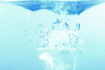 Fototapeta na wymiar Ice cube fall in the water - refreshing splash .