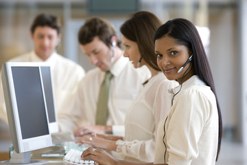 Young call center woman with colleagues