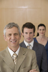 Mature businessman with team behind him