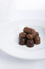 Pile of chocolate assortment on the white plate