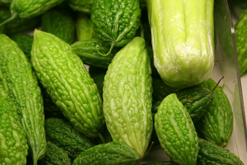 A tray of bitter gourds in a market.