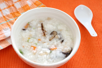 Chinese dimsum porridge with sliced mushrooms and vegetables