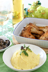 Mash potato with basil heaped up in a white ceramic bowl