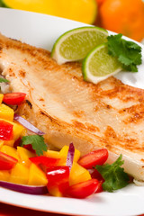 Closeup of fried skate (ray) with mango, tomato and onion