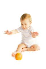 baby tryinh to catch an orange over white