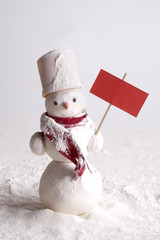 Snowy snowman with blank red board