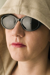 Frau mit Sonnenbrille und Kapuze