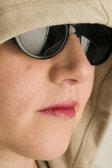 Frau mit Kapuze und Sonnenbrille