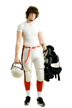 An American football player. Standing with helmet and pads.