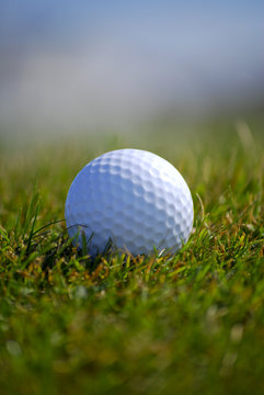 Closely focussed image in a golf ball on grass